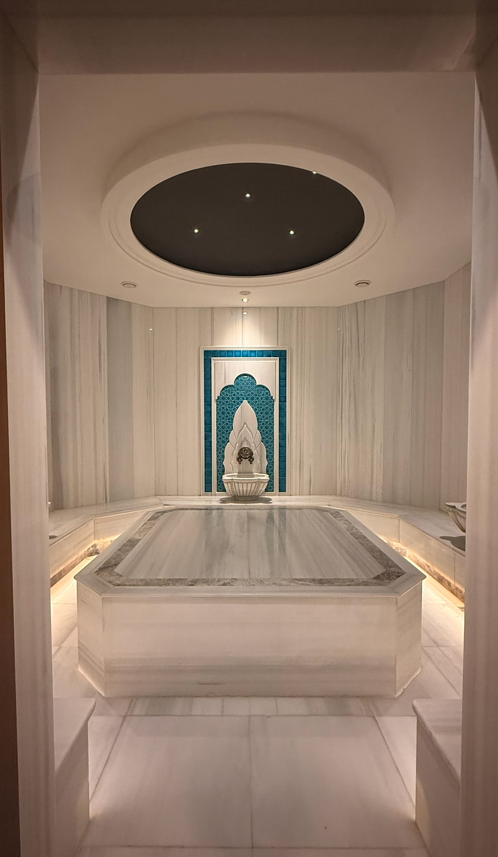 White marble hammam interior with a central bathing platform.